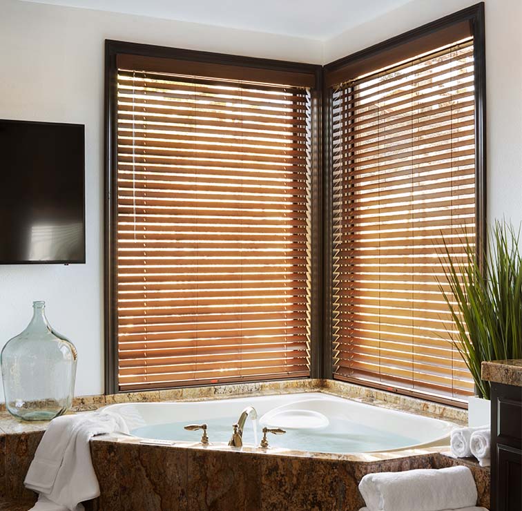 Faux Wood Blinds in a bathroom with a corner tub and windows
